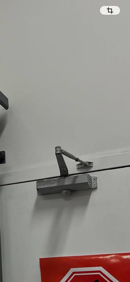 Surface-mounted hydraulic door closer installed on a fire-rated door in Ottawa