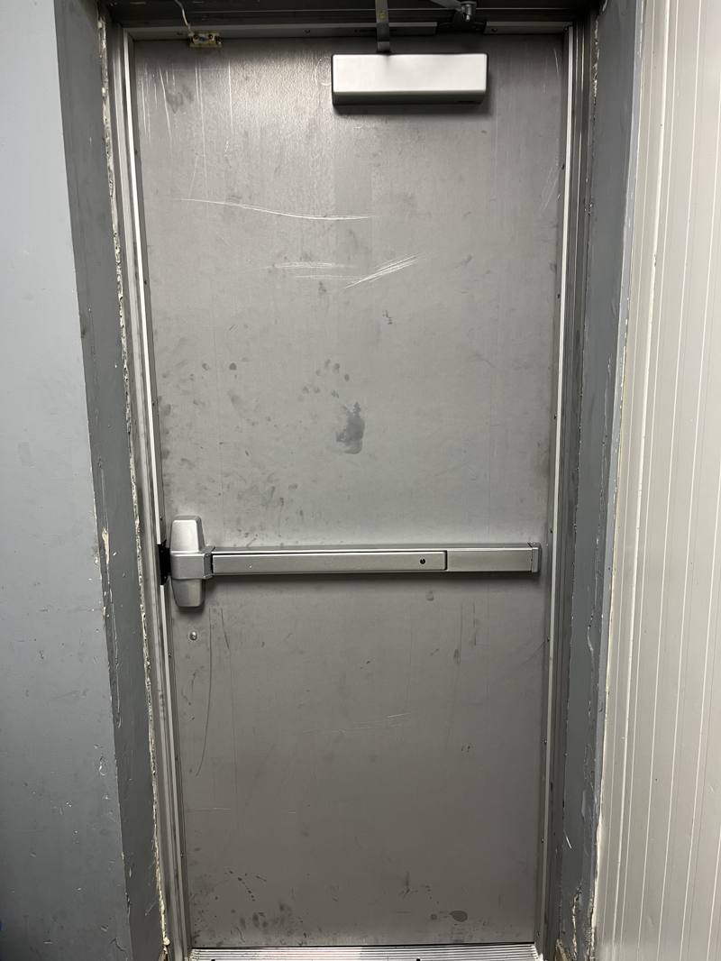 Panic bar exit device fitted on a commercial steel door in Ottawa