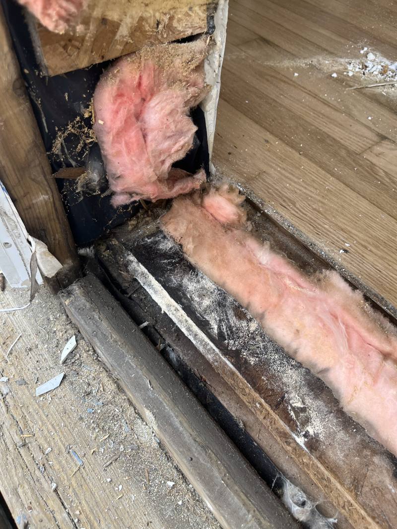 Rotted exterior door frame opened up to expose damaged wood and insulation in Ottawa