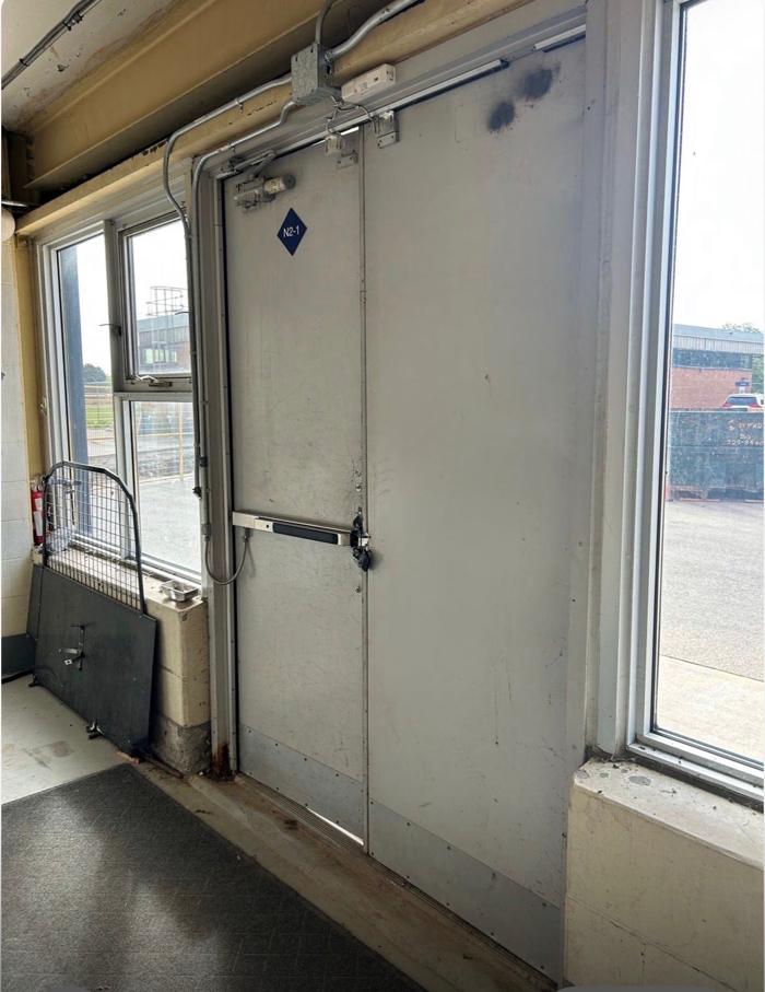 Before: exterior of the original school doors with the old pull handle and kick plates prior to replacement