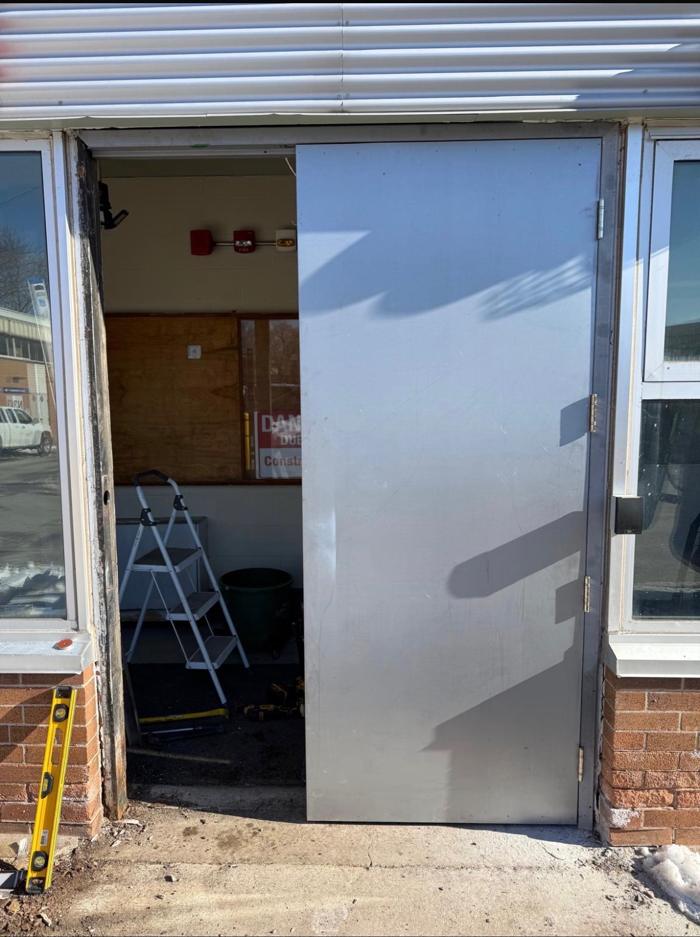 In process: the new steel door hung in the frame mid-installation at the Ottawa school, with the opening still being worked on