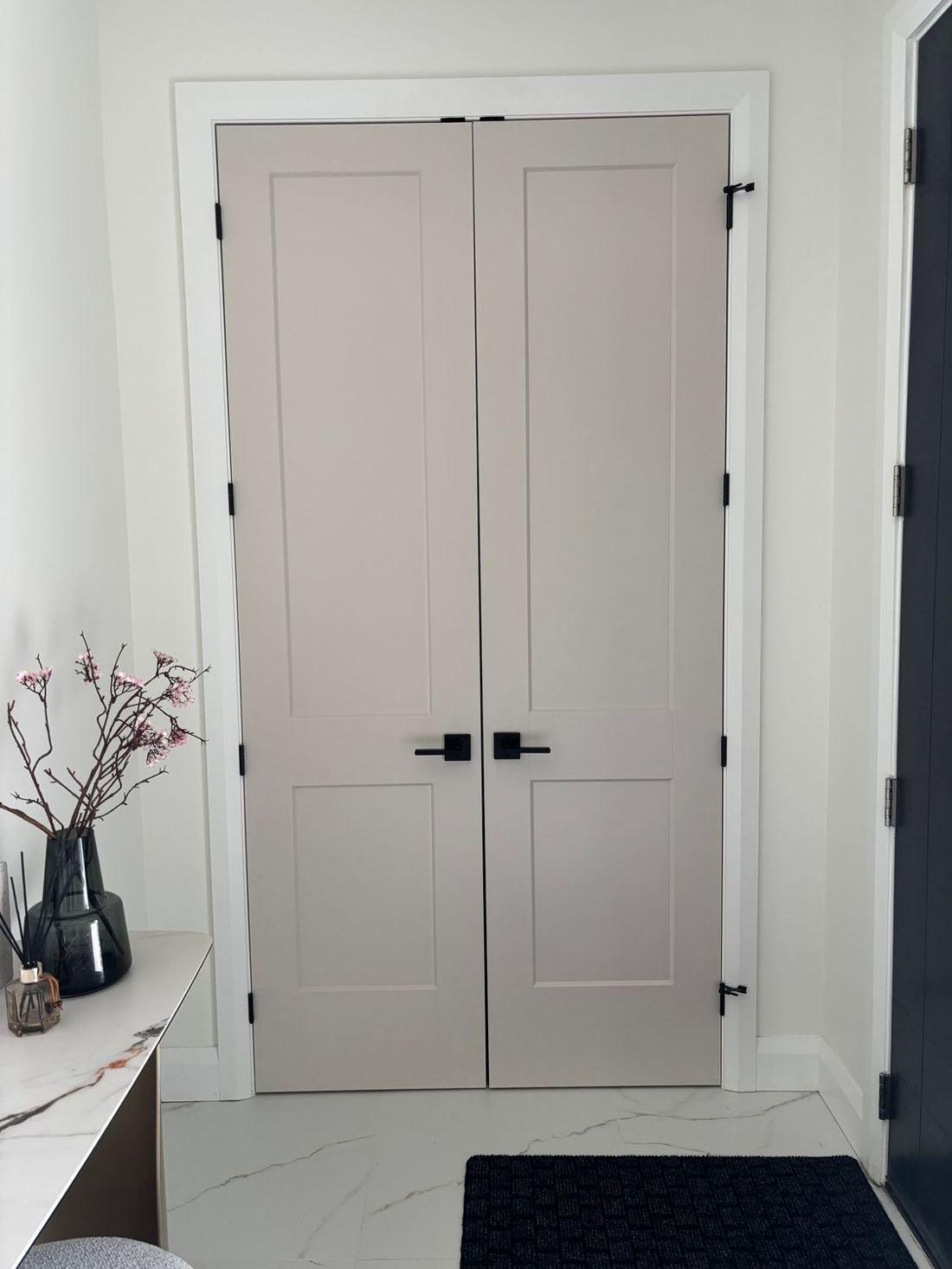 8 ft white shaker-panel closet doors with black bar handles installed in an Ottawa home