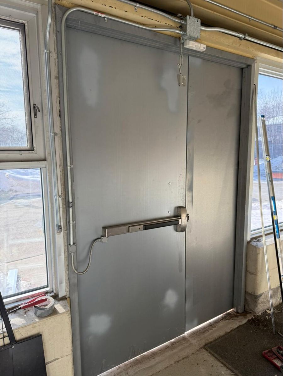 New commercial hollow steel double doors installed at an Ottawa school, complete with an electrified panic bar, door closers and fire alarm contacts