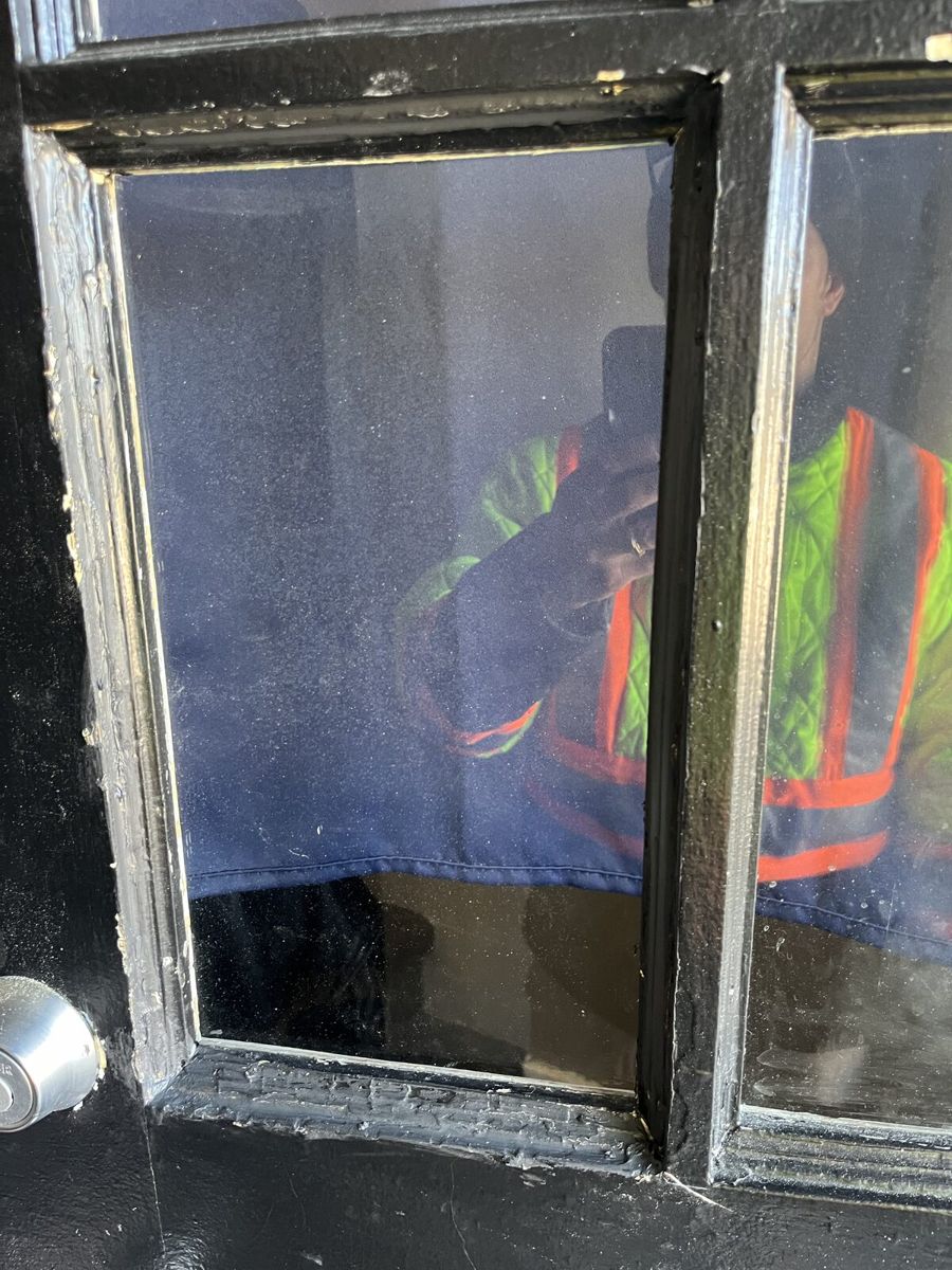 New clear glass pane installed in the same black Ottawa entry door after repair