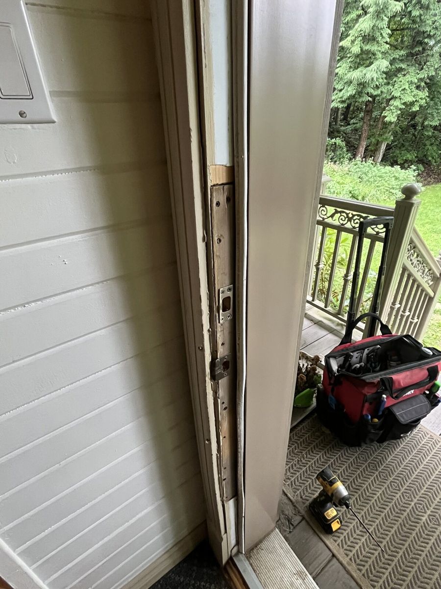 Worn, leaking exterior door threshold with old weatherstripping removed at an Ottawa home before repair