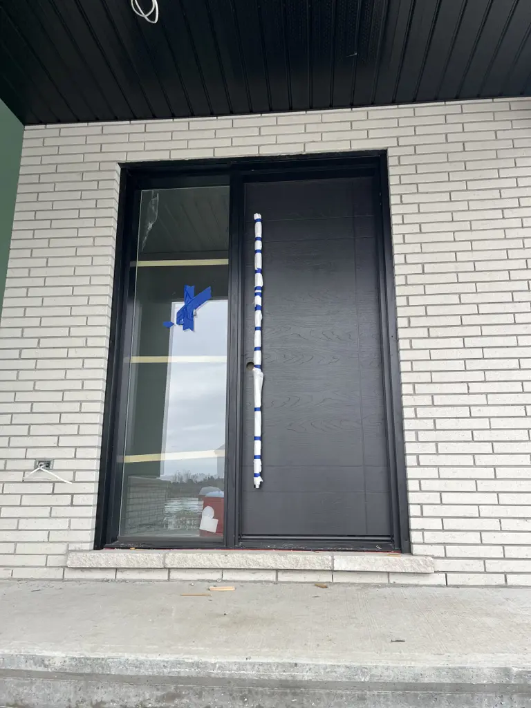 8 ft custom black exterior door with a full-height glass sidelite installed in an Ottawa entrance