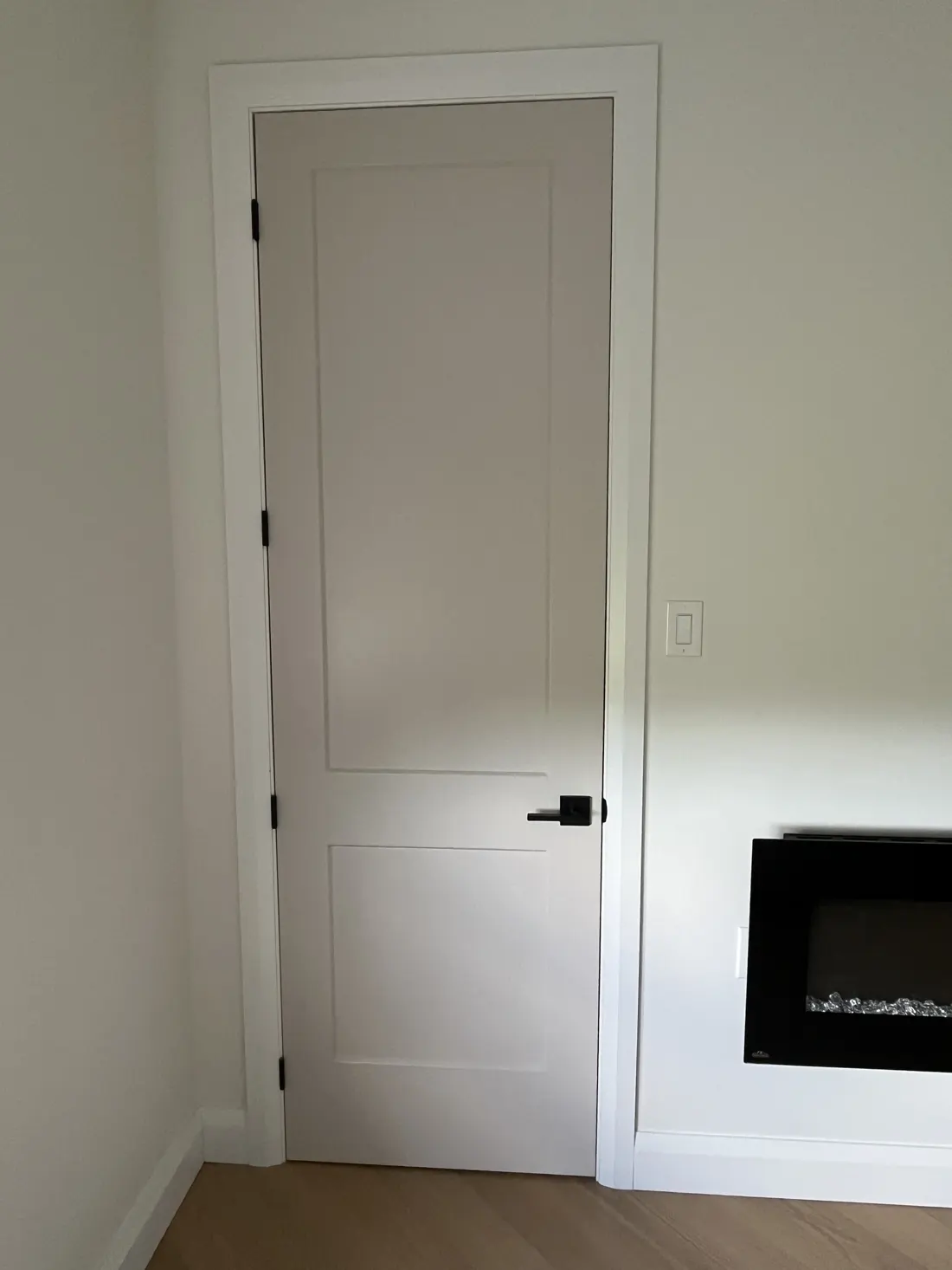 Interior 8 ft door installed in an Ottawa home with white casing and black hardware