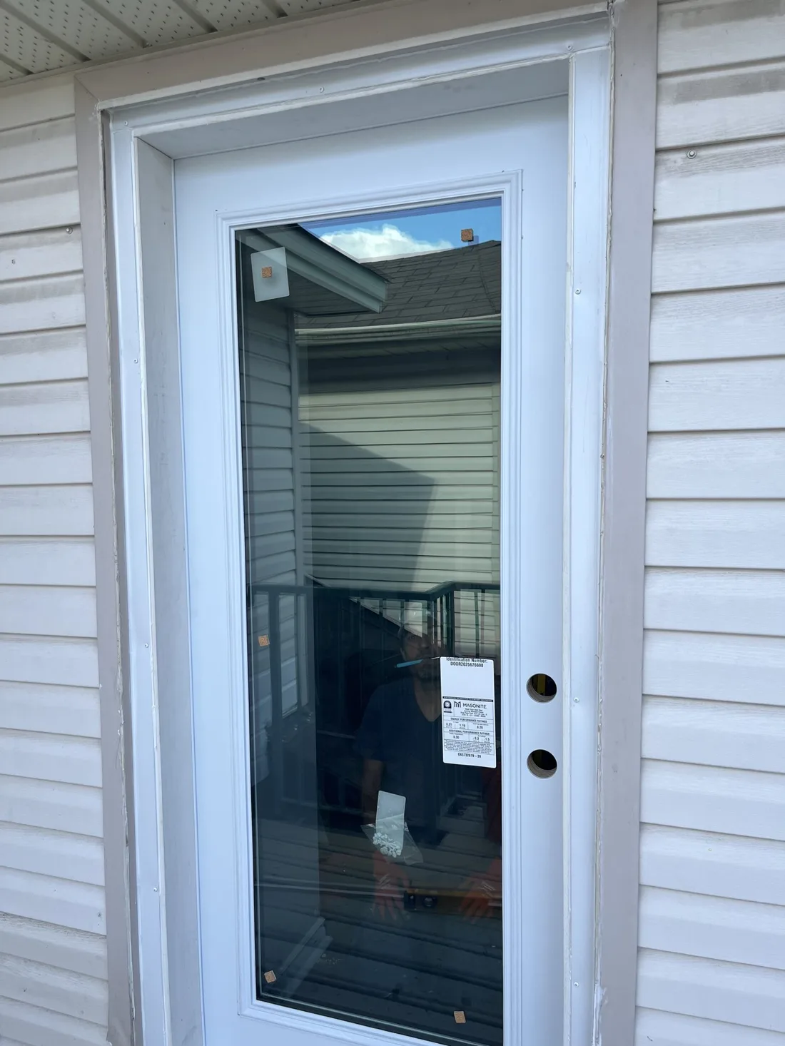 Finished white exterior replacement door with a full glass panel after water-damage repair in Ottawa