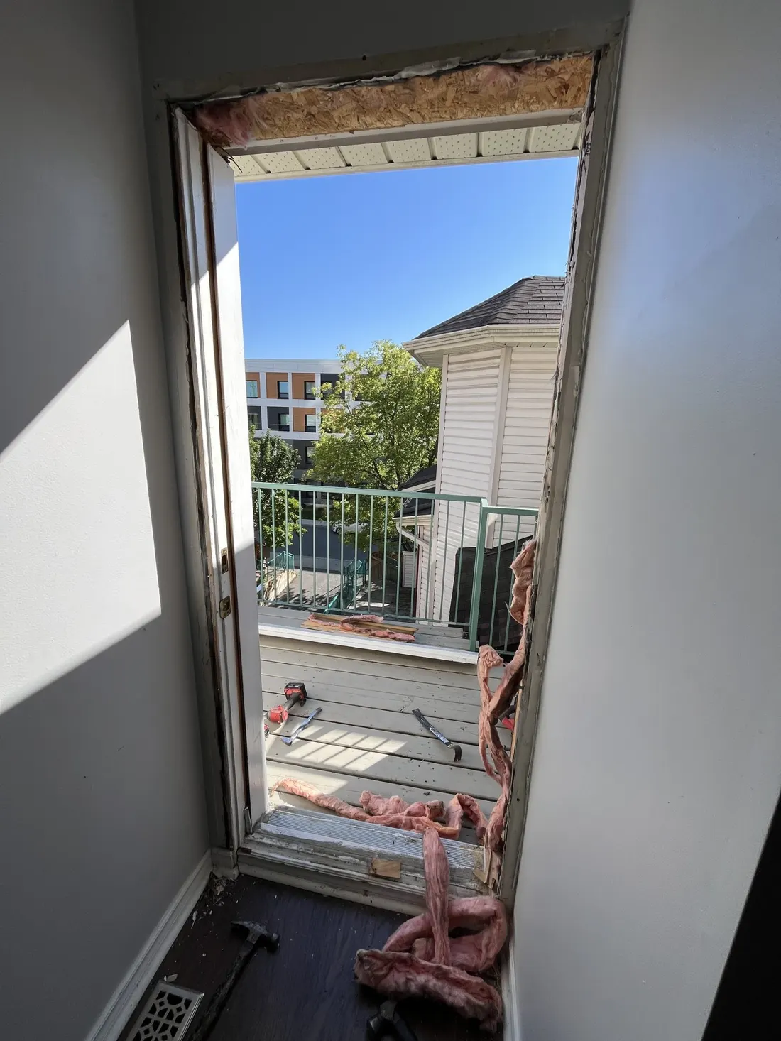 Exterior door opening exposed after removal of the old door, looking out to the deck