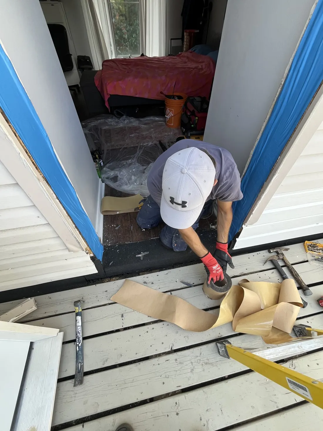 Technician applying flashing tape around a prepared exterior door opening