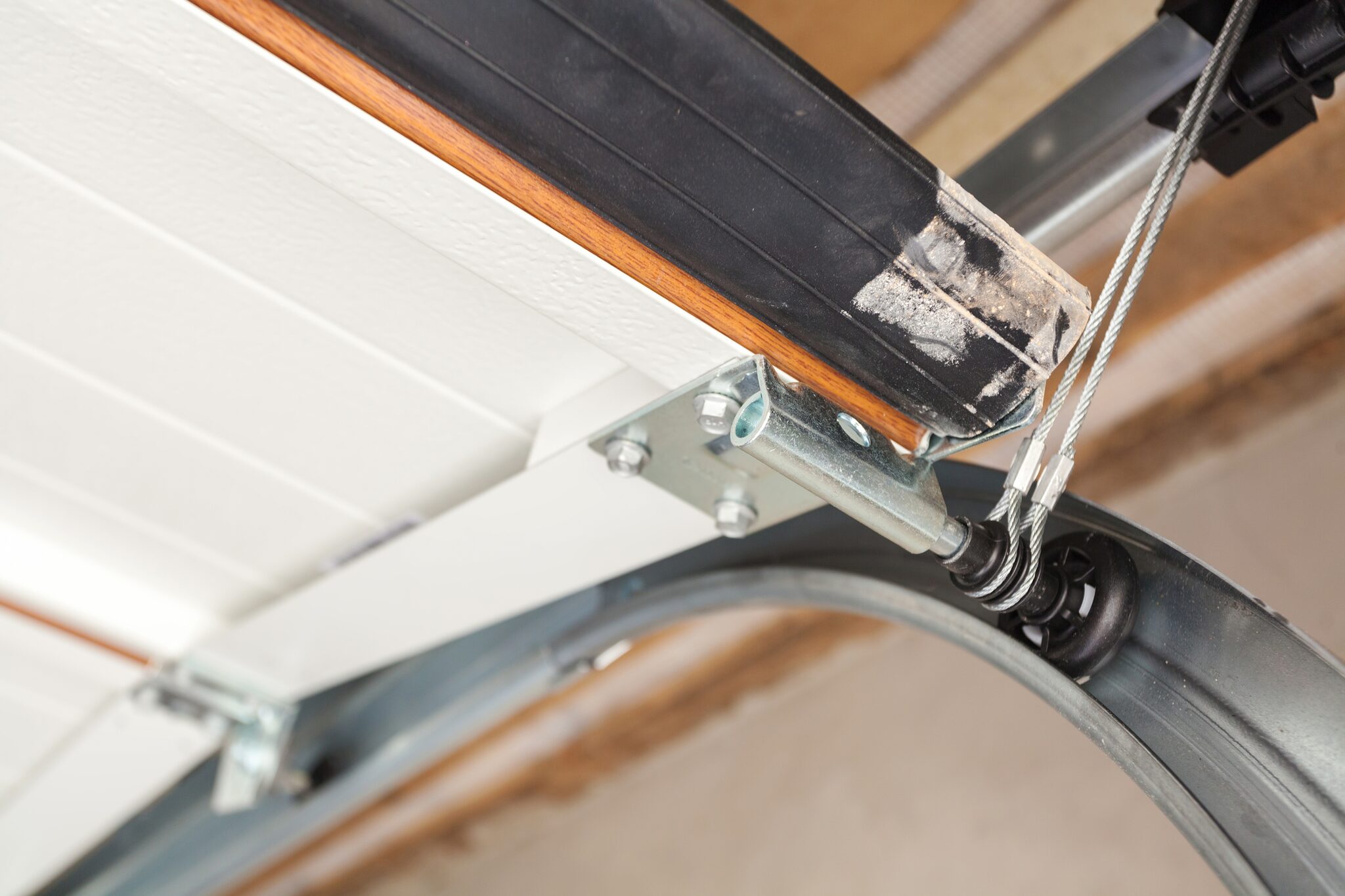 Garage door track, roller, and lift cable on a sectional door