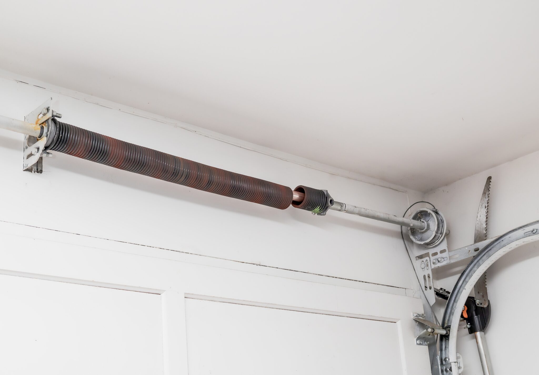 Garage door extension spring, pulley, and lift cable along the track