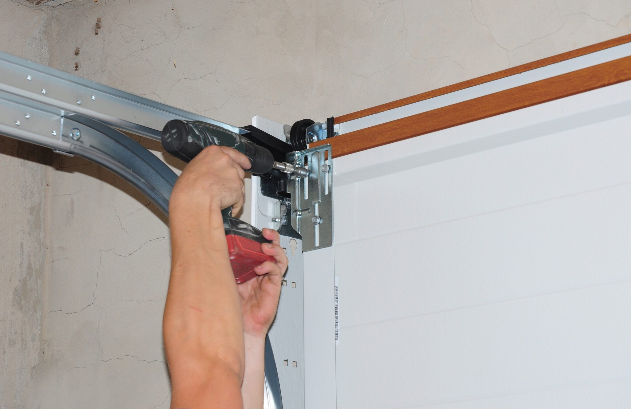 Garage door roller and bracket being installed on a sectional door